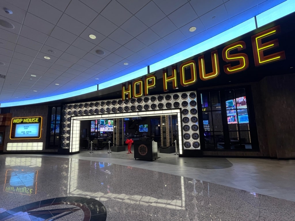 promenade entrance into Hop House sports bar with a archway of glowing kegs and bold, lit overhead signage